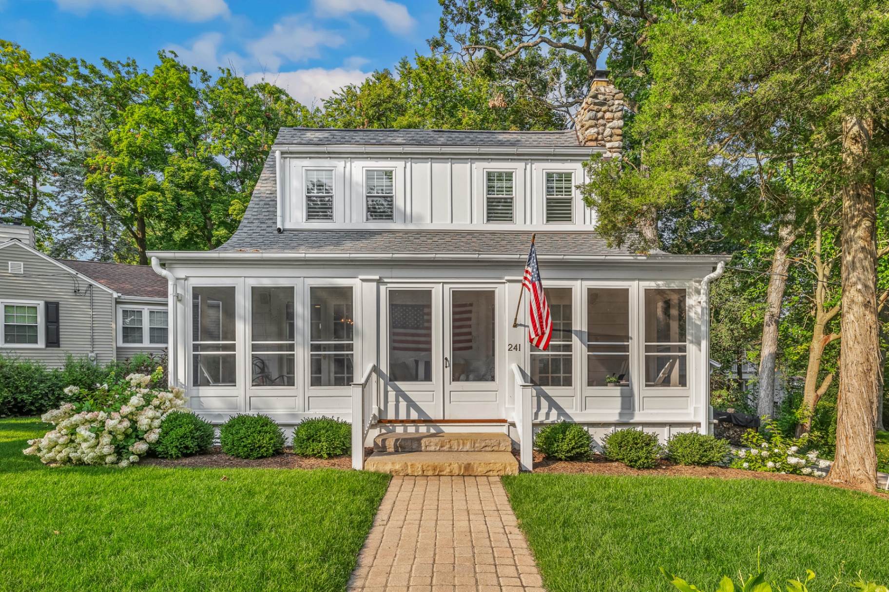 White board-and-batten cottage with screened porch